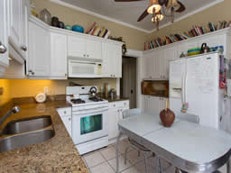 The kitchen has granite counters and raised white panel cabinetry