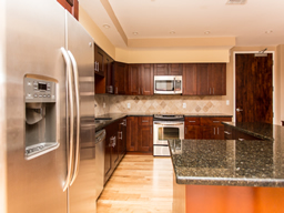 Marble counters, stainless steel appliances, cherry cabinetry