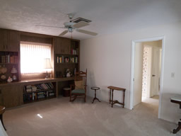 This bedroom has a wall of built-in bookcases