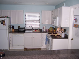 The updated kitchen has white cabinetry & appliances.
