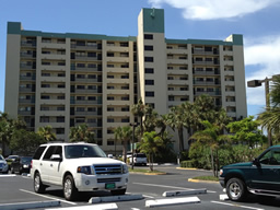 The building has a guard gate and open parking