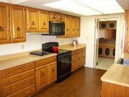 The galley kitchen has wood cabinetry and some newer appliances.