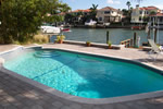 A free form pool surrounded by paver decking